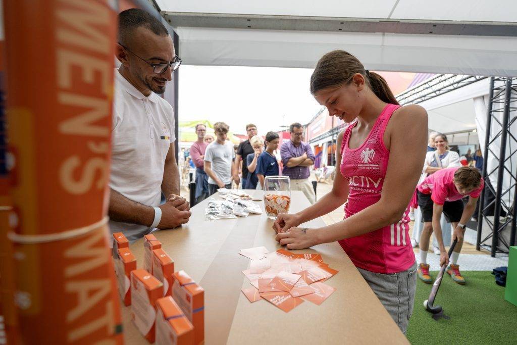 Girl scratches to see which price she won at the PostNL activation stand at the 2026 FIH Hockey World Cup